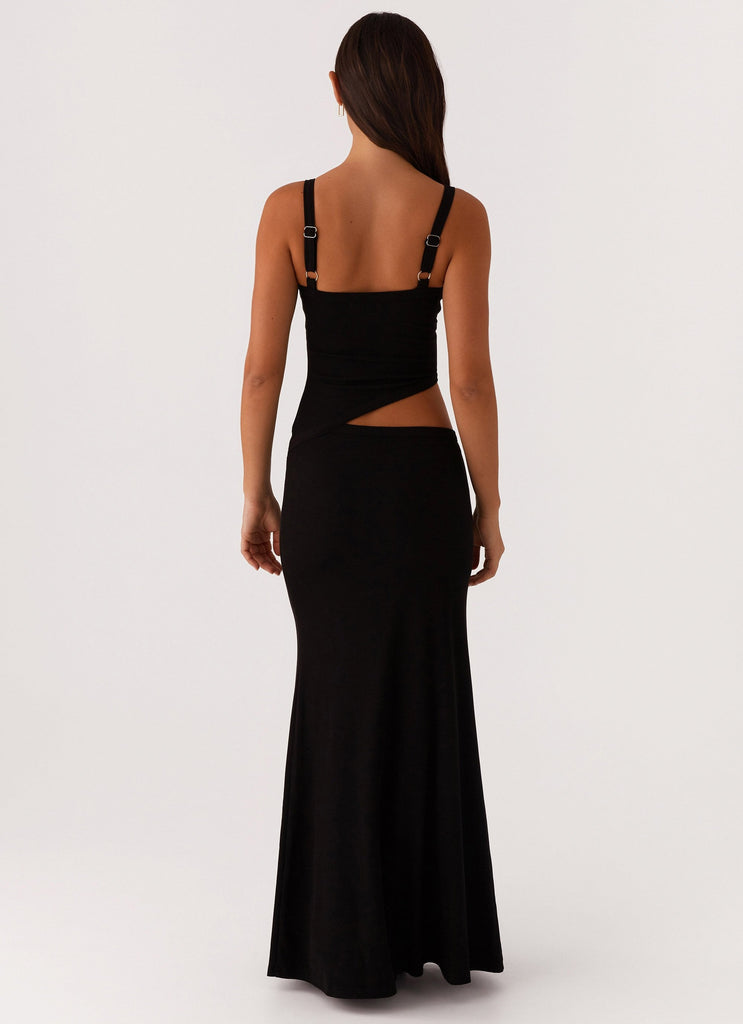 Back view of a black knit maxi dress, highlighting the side cut-out and adjustable strap hardware.