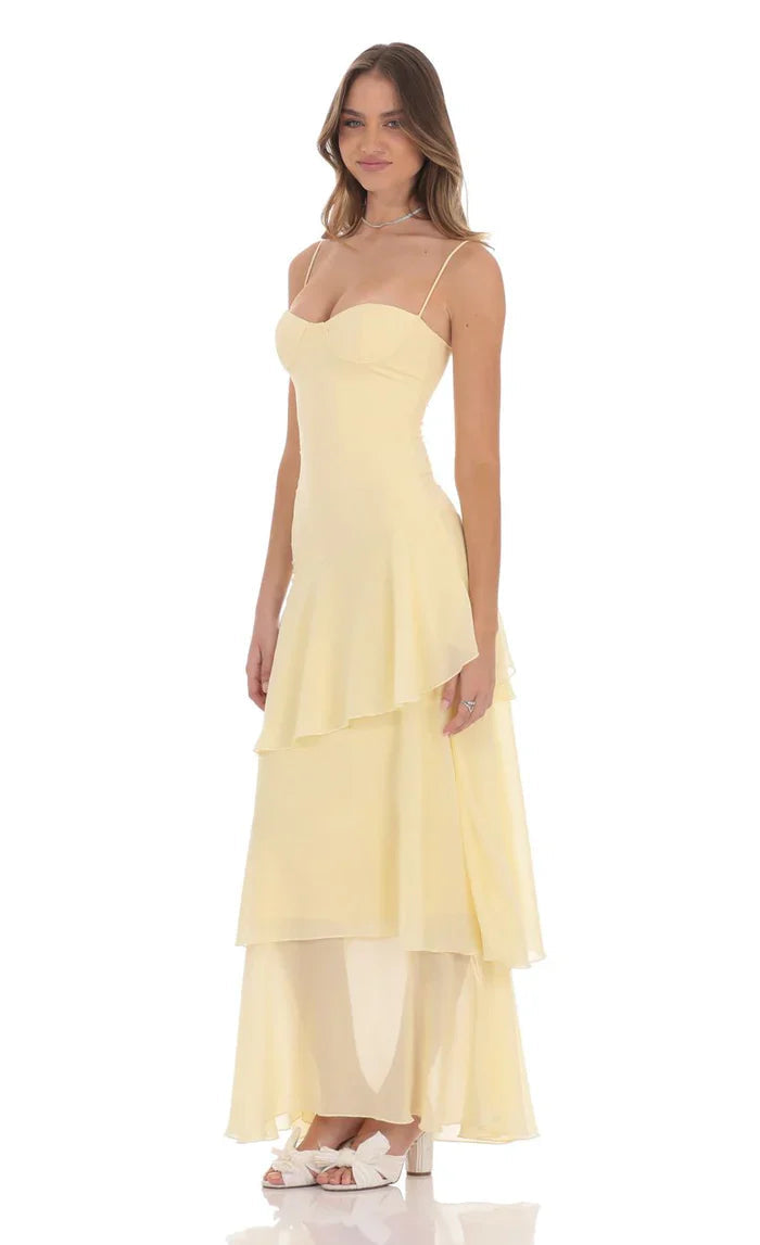 Side view of light yellow tiered ruffle maxi dress, fitted bodice and flowy layered skirt