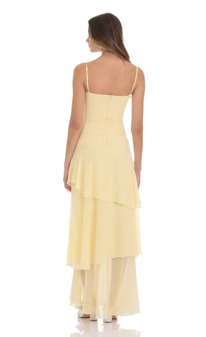Back view of pale yellow maxi dress with thin straps, zip back bodice, and tiered ruffle skirt